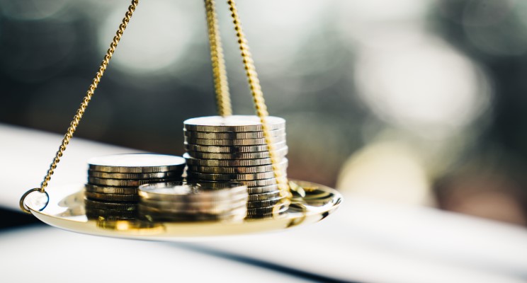 coins balancing on weighing scales