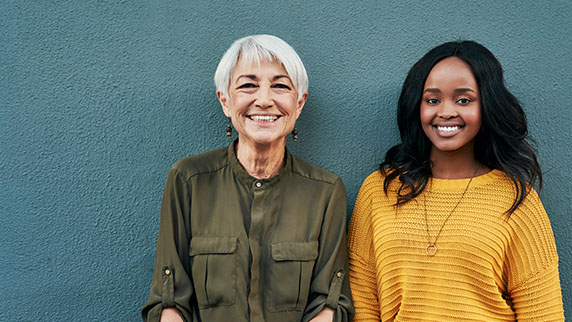Two women against a blue green wall
