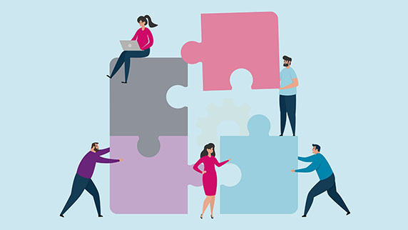 Group of people problem solving a giant puzzle