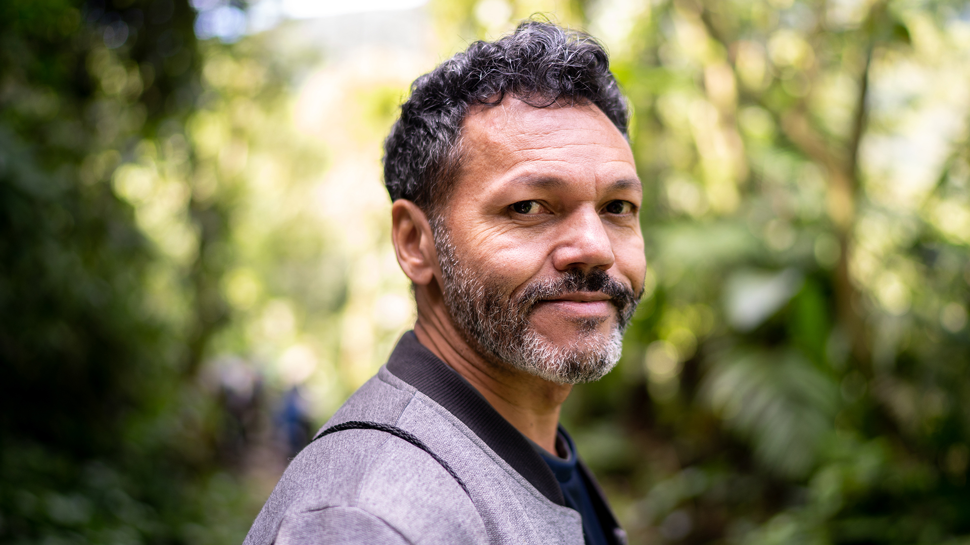 Man looking at the camera with trees in the background