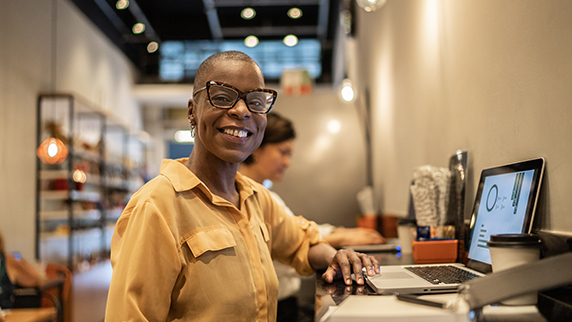 Woman at laptop smiling at camera