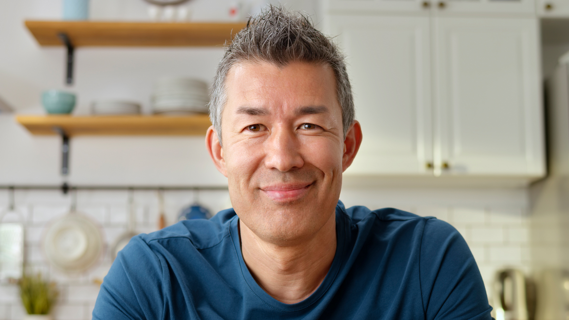 Man in kitchen smiling at camera